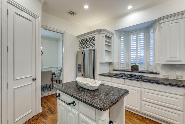 kitchen featuring white cabinets, dark stone countertops, light hardwood / wood-style floors, and appliances with stainless steel finishes