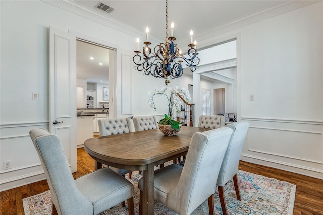 dining area featuring a notable chandelier, ornamental molding, and dark hardwood / wood-style floors