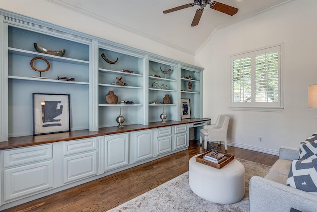 sitting room featuring built in desk, ornamental molding, dark hardwood / wood-style flooring, ceiling fan, and lofted ceiling