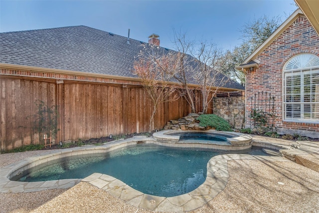 view of swimming pool with an in ground hot tub