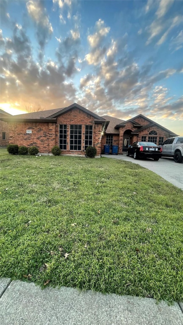 single story home featuring a lawn