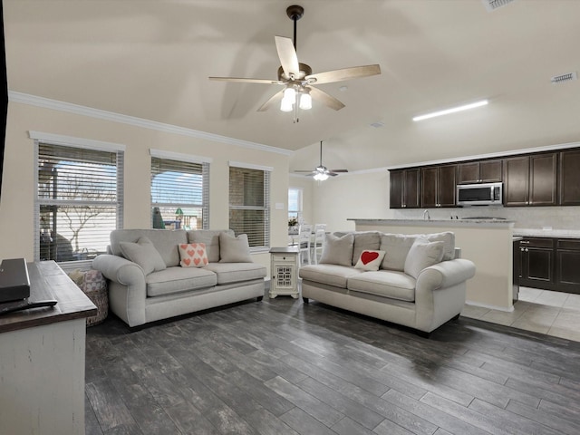 living area with ceiling fan, wood finished floors, visible vents, and ornamental molding