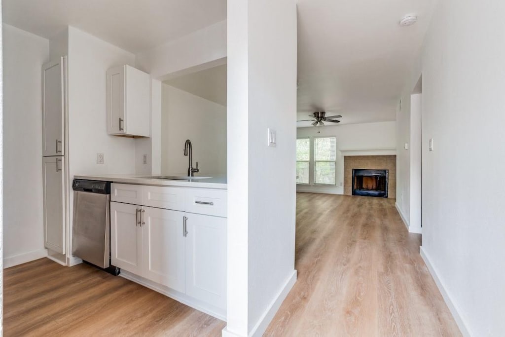 kitchen featuring ceiling fan, dishwasher, white cabinetry, and light hardwood / wood-style flooring