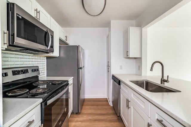 kitchen with backsplash, sink, white cabinets, and appliances with stainless steel finishes