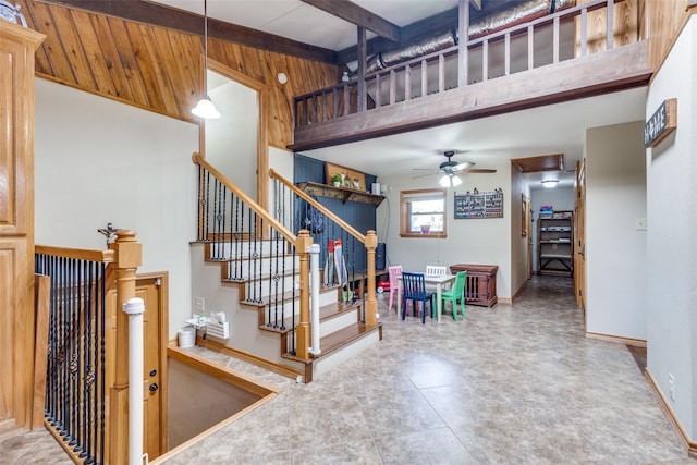 staircase featuring ceiling fan and beamed ceiling