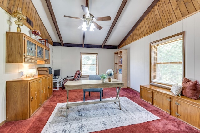 office space featuring ceiling fan, lofted ceiling with beams, wooden walls, and dark carpet