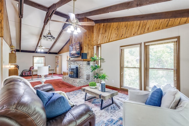 living room featuring ceiling fan, lofted ceiling with beams, wooden walls, and a wood stove