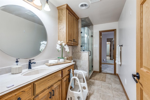 bathroom with toilet, vanity, tile patterned floors, a bidet, and an enclosed shower