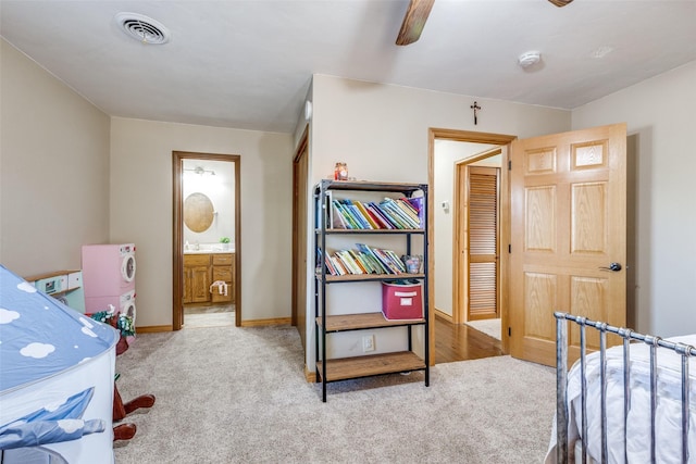 bedroom featuring ensuite bath, ceiling fan, and light carpet