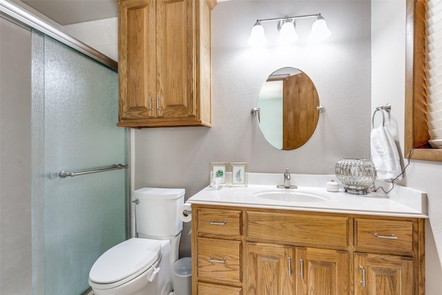 bathroom with toilet, a shower with door, and vanity