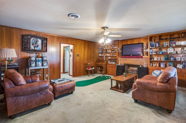 carpeted living room featuring ceiling fan, built in features, wood walls, and a fireplace