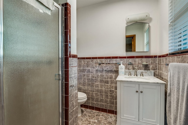 bathroom featuring toilet, tile walls, and a shower with shower door