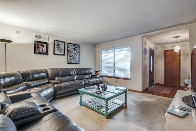 carpeted living room featuring a chandelier