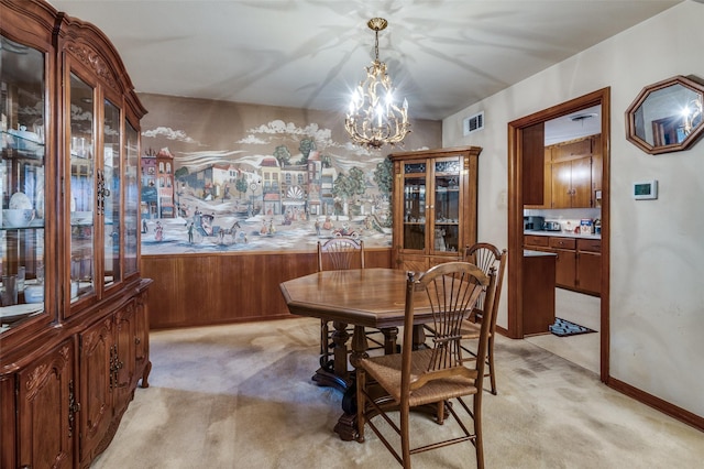 dining room featuring light colored carpet and an inviting chandelier