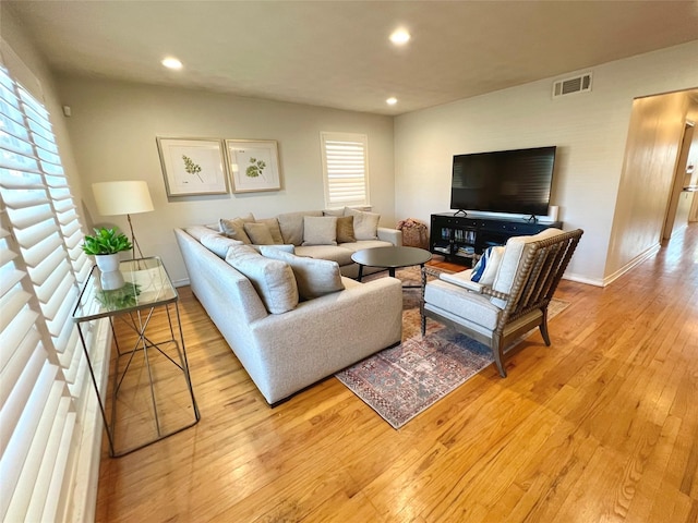 living room with plenty of natural light and light hardwood / wood-style flooring