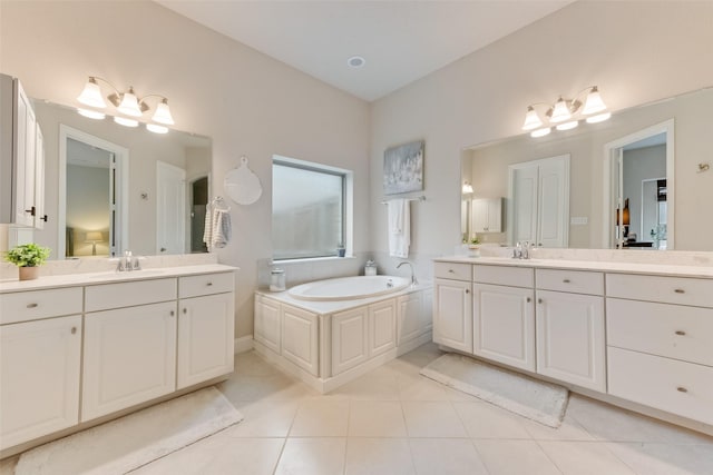 bathroom with a tub to relax in, tile patterned floors, and vanity