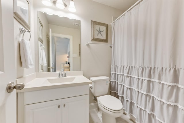 bathroom featuring toilet, vanity, and a shower with curtain