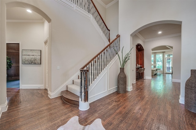 foyer entrance with dark hardwood / wood-style flooring and ornamental molding