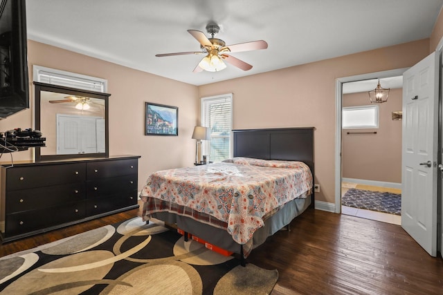 bedroom featuring ceiling fan, dark wood-type flooring, and multiple windows