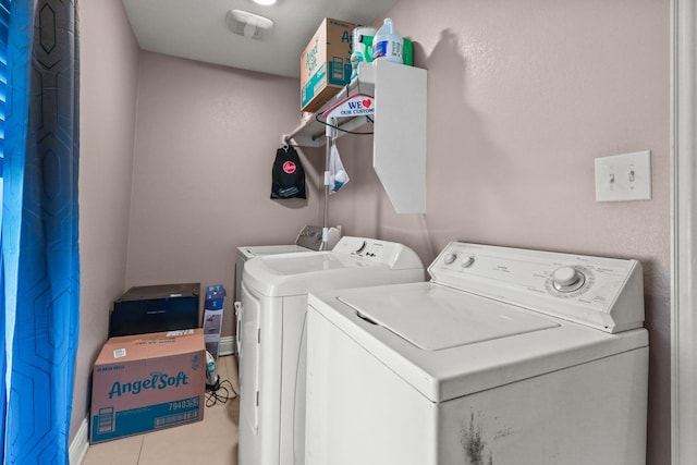 laundry room with light tile patterned floors and washing machine and clothes dryer