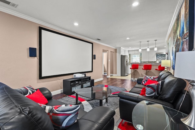 cinema room with light hardwood / wood-style flooring and ornamental molding