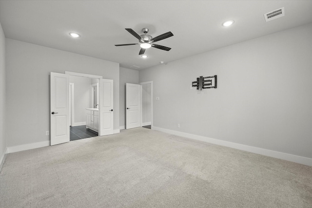 unfurnished bedroom with ceiling fan and dark carpet