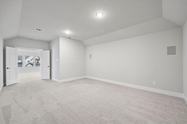 additional living space with vaulted ceiling and light carpet