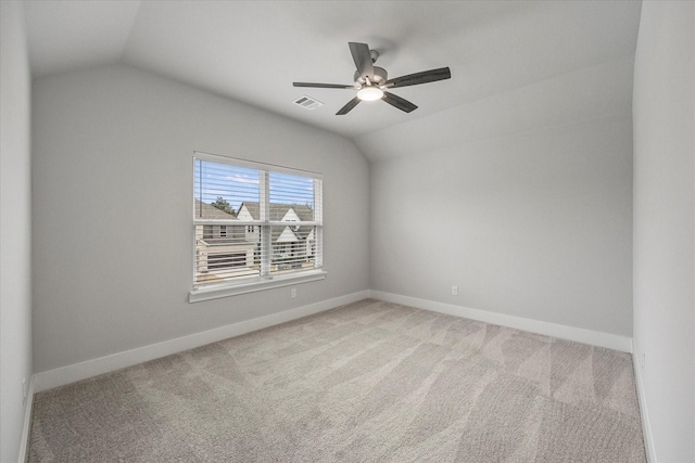 carpeted spare room with ceiling fan and lofted ceiling