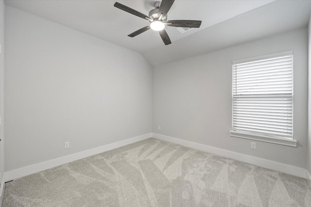 empty room featuring ceiling fan, light colored carpet, and vaulted ceiling