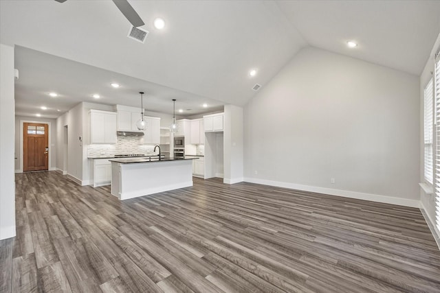 unfurnished living room featuring vaulted ceiling, dark wood-type flooring, and sink