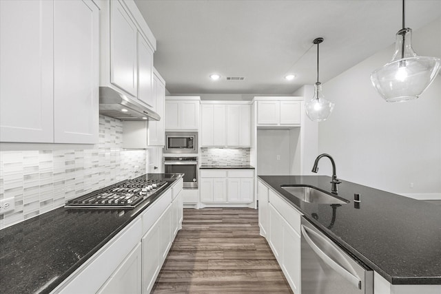 kitchen with appliances with stainless steel finishes, pendant lighting, white cabinets, and sink