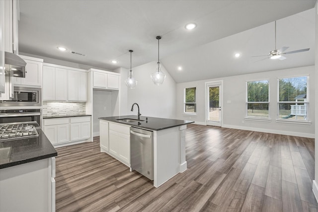 kitchen with stainless steel appliances, a kitchen island with sink, lofted ceiling, white cabinets, and sink