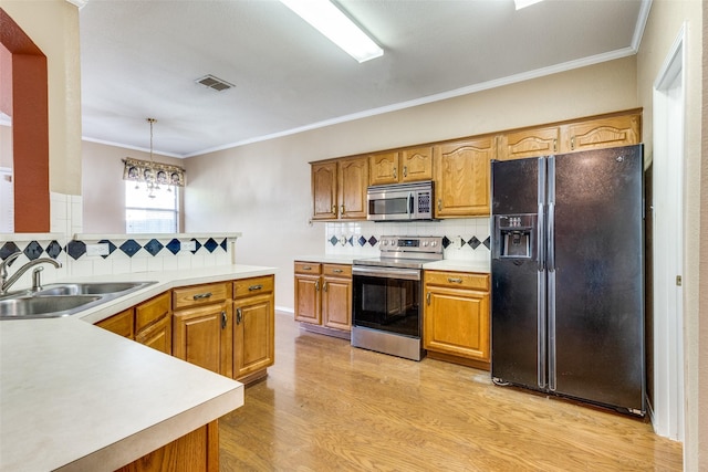 kitchen featuring stainless steel appliances, a sink, visible vents, light countertops, and pendant lighting