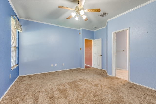 unfurnished bedroom with crown molding, visible vents, a ceiling fan, light carpet, and baseboards