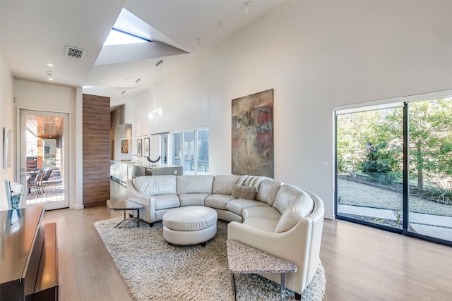 living room featuring light hardwood / wood-style flooring and high vaulted ceiling