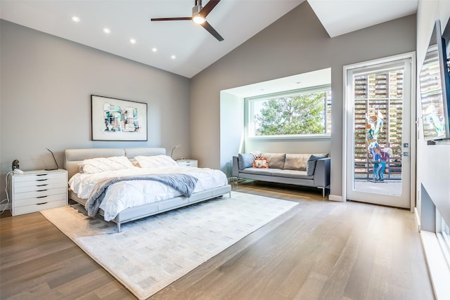 bedroom with ceiling fan, access to exterior, hardwood / wood-style floors, and high vaulted ceiling