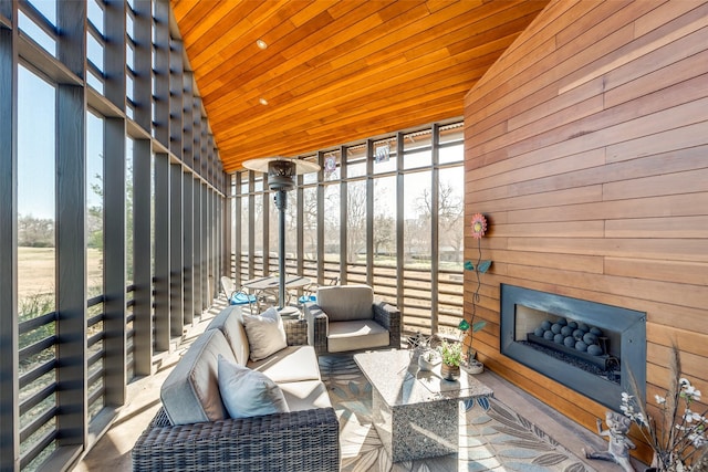 sunroom / solarium featuring a fireplace, vaulted ceiling, and wood ceiling