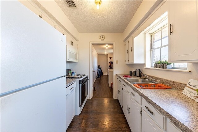 kitchen with white appliances, white cabinets, a textured ceiling, dark hardwood / wood-style flooring, and sink