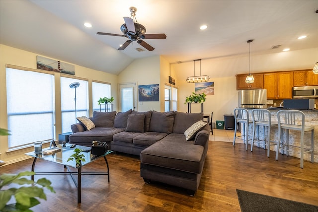 living room featuring ceiling fan, dark wood-type flooring, and vaulted ceiling