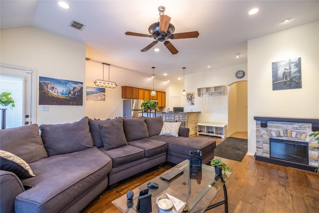 living room with vaulted ceiling, ceiling fan, a fireplace, and hardwood / wood-style floors