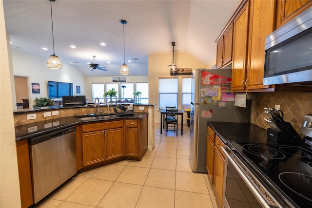 kitchen with ceiling fan, lofted ceiling, appliances with stainless steel finishes, and pendant lighting