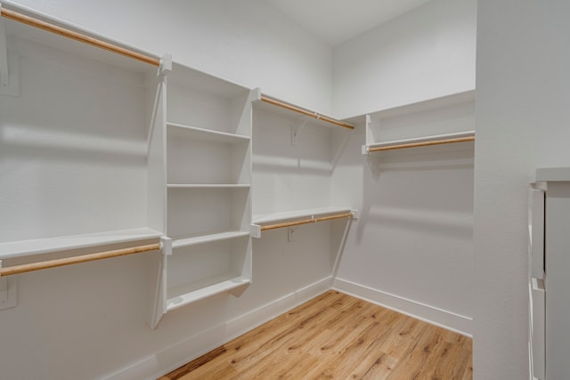 walk in closet with hardwood / wood-style flooring