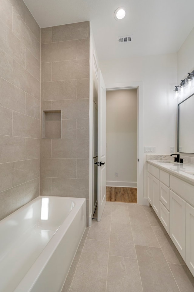 bathroom with tile patterned flooring, vanity, and a bathtub