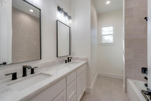 bathroom with tile patterned flooring, tiled shower / bath, and vanity