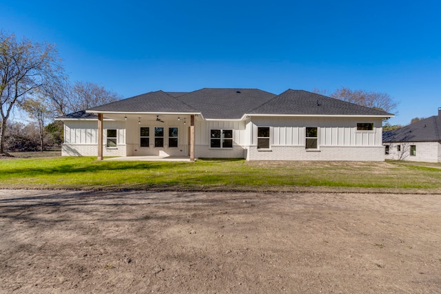 back of property featuring ceiling fan, a patio area, and a lawn