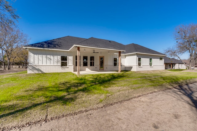 rear view of house featuring ceiling fan, a yard, and a patio