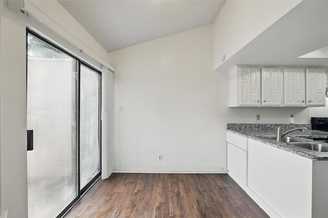 821 Dublin Dr Unit 203, Richardson, TX 75080 - kitchen featuring dark wood finished floors, baseboards, white cabinetry, and a sink