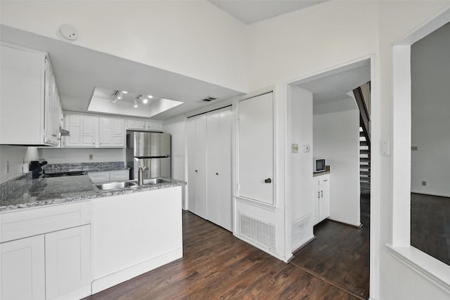 821 Dublin Dr Unit 203, Richardson, TX 75080 - kitchen featuring a sink, a raised ceiling, visible vents, a peninsula, and freestanding refrigerator