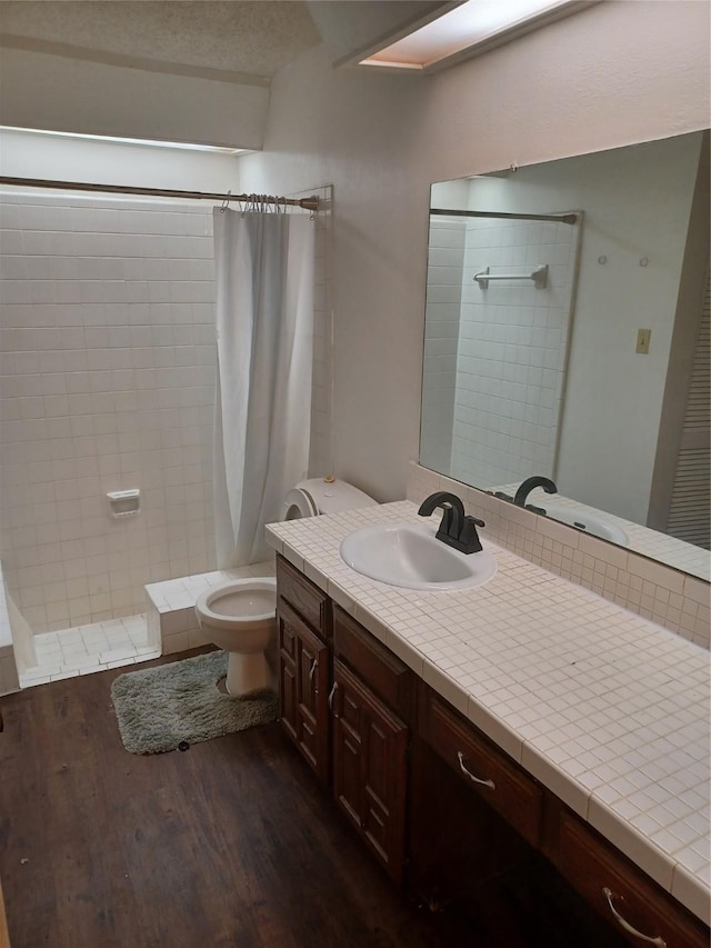 bathroom featuring toilet, vanity, a shower with shower curtain, and hardwood / wood-style flooring