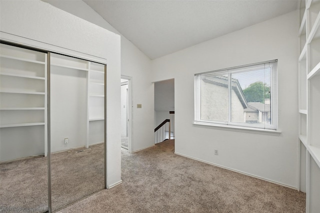 821 Dublin Dr Unit 203, Richardson, TX 75080 - unfurnished bedroom featuring a closet, vaulted ceiling, and carpet floors